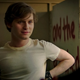 Fred Hechinger wears a while shirt in front of a wall with graffiti in a scene from Fear Street.